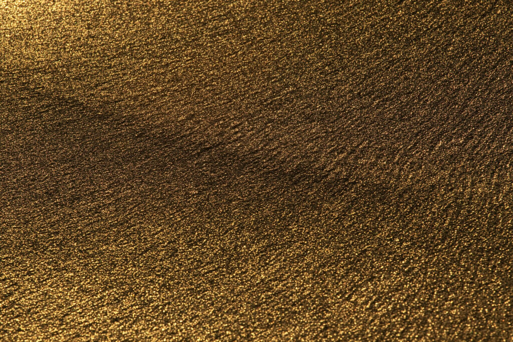 Złocisty, mokry piasek na plaży w świetle wschodzącego słońca – abstrakcyjna struktura | fot. Marcin Skrobisz