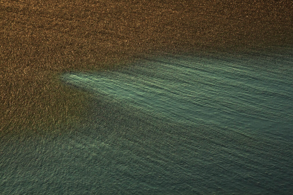 Cienka warstwa wody na złocistym piasku o wschodzie słońca | fot. Marcin Skrobisz