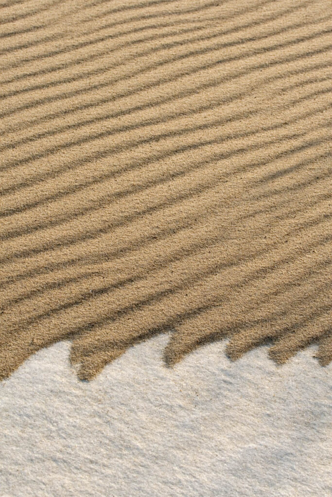 Fale piasku na śniegu – kontrastowe wzory utworzone przez wiatr na zimowym krajobrazie plaży | fot. Marcin Skrobisz