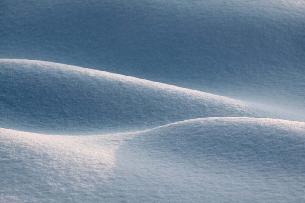 Delikatne zaspy śniegu uformowane w miękkie fale przez wiatr i światło poranka | fot. Marcin Skrobisz